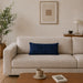 Rectangular navy filled cushion with intersecting geometric stitching on a cream sofa.