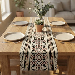 Cream table runner with black and rust geometric diamonds on a wooden dining table.
