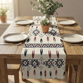 Cream table runner with blue and rust geometric motifs on a wooden dining table.