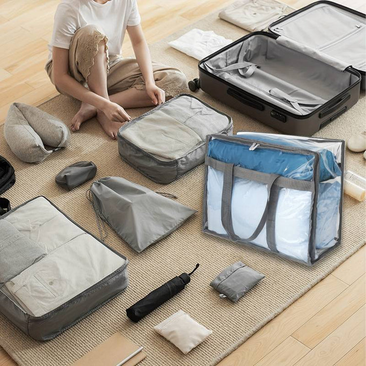 Person packing travel items beside an open suitcase and clear bedding-storage bag