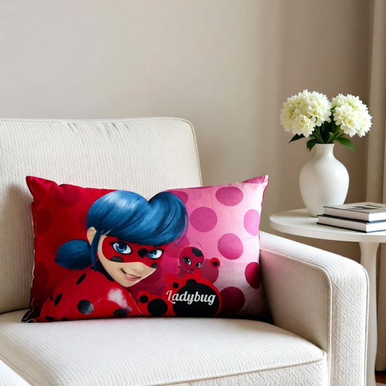 Ladybug character cushion cover displayed on a white armchair beside a window.
