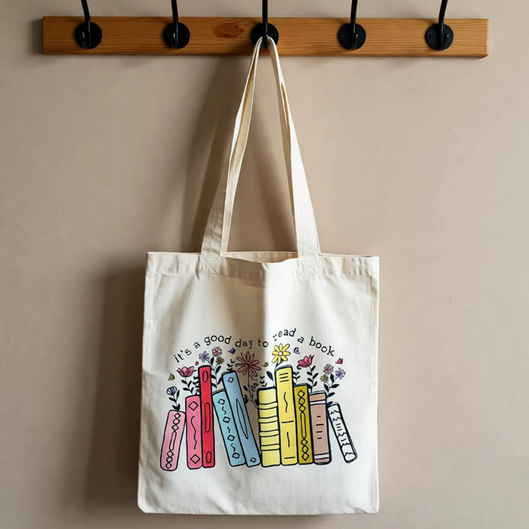 Cream tote bag with colourful books and small flowers.