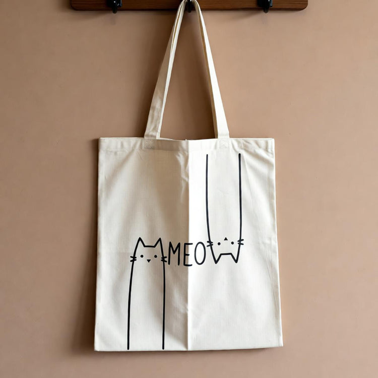 Cream tote bag with a minimalist cat outline and Meow lettering.