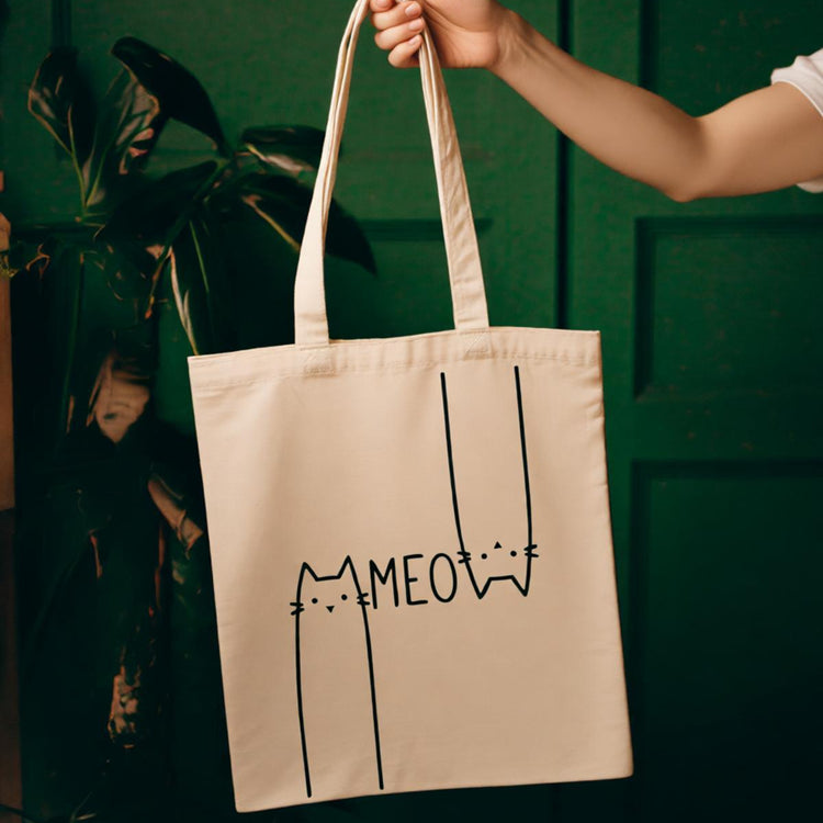 Cream tote bag with a minimalist cat outline and Meow lettering.