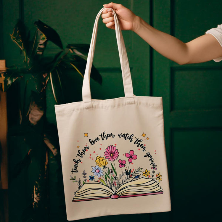 Cream tote bag with an open book and colourful flowers.