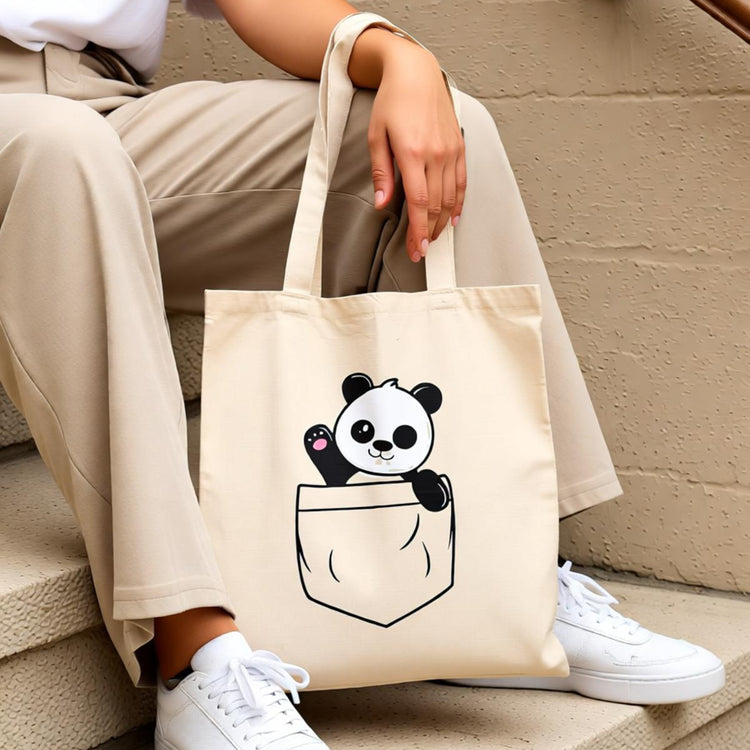 Cream tote bag with a cartoon panda peeking out of an illustrated pocket.