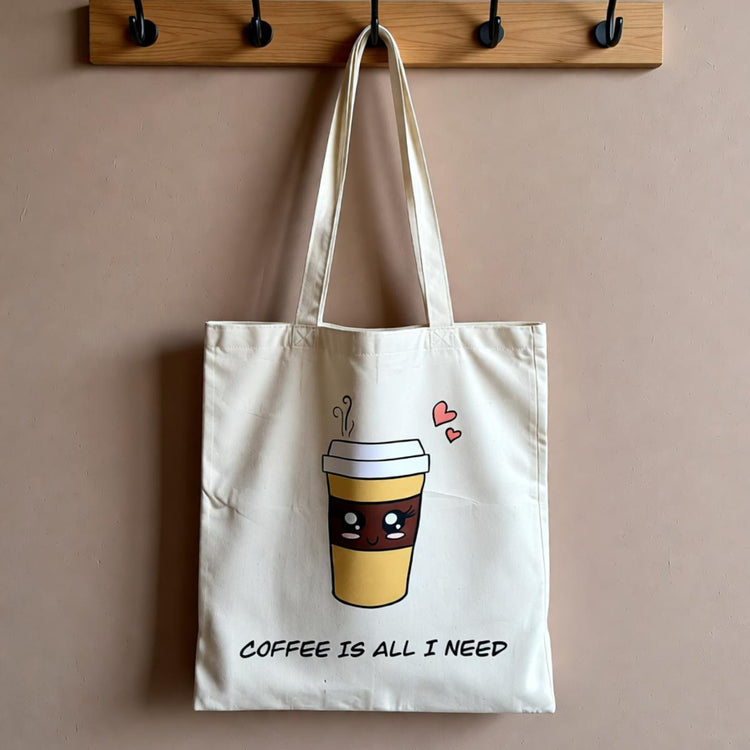 Cream tote bag with a takeaway coffee cup illustration and coffee-themed lettering.