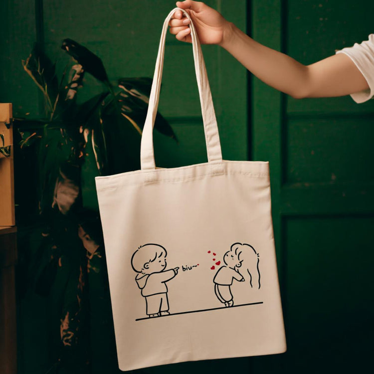 Cream tote bag with a simple line drawing of two people exchanging a heart.