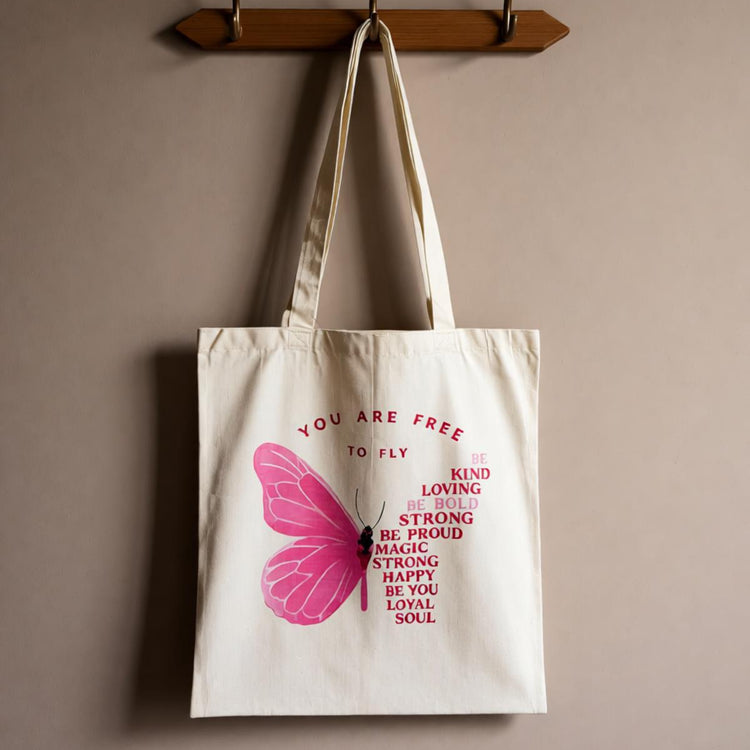 Cream tote bag with a pink butterfly and motivational lettering.