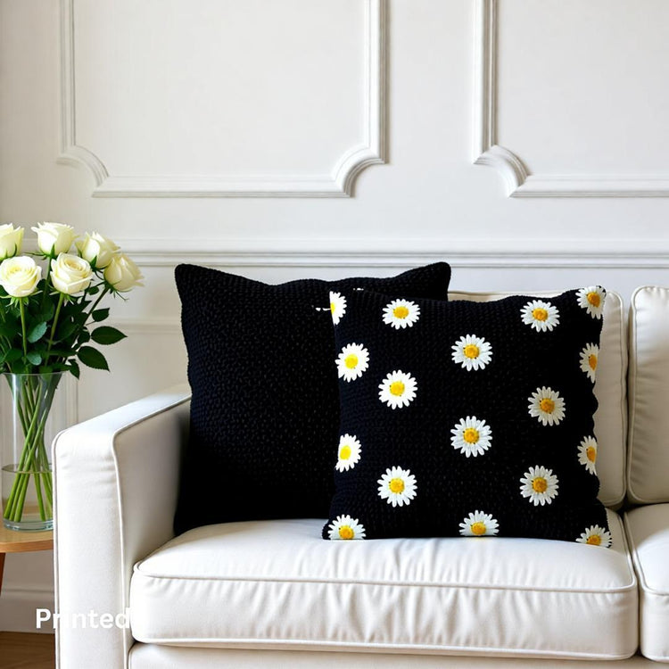 Black cushion covers with small scattered white daisies on a white sofa.