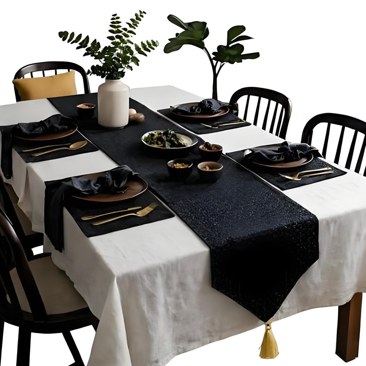 Black table runner with matching placemats over a white tablecloth.