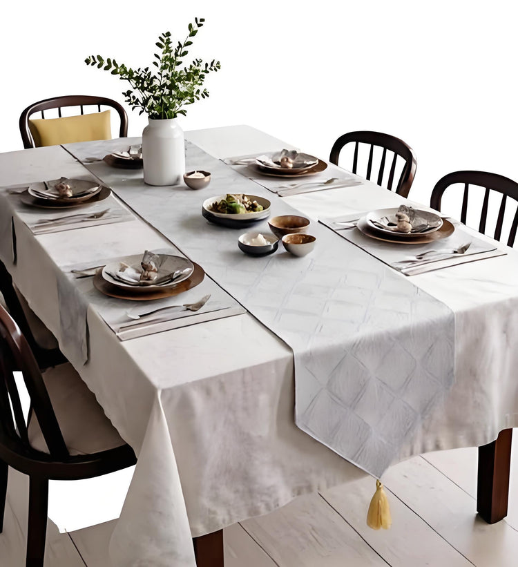 Silver-grey patterned table runner and matching placemats on a set table.