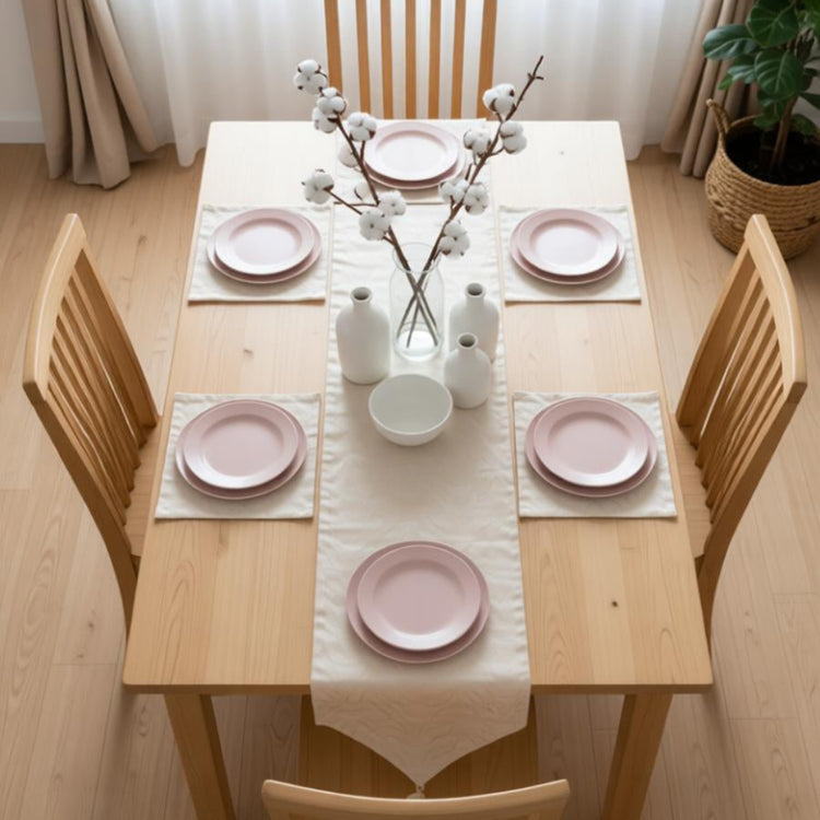 Plain cream table runner with matching placemats on a dining table.