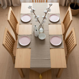 Sand-coloured table runner with subtle horizontal lines and matching placemats.