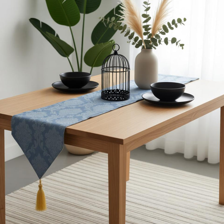Blue ornamental table runner with a pointed tasselled end.
