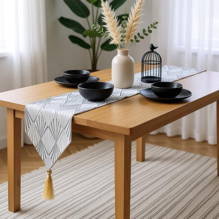 Silver-grey chevron-pattern table runner with a gold-coloured tassel.