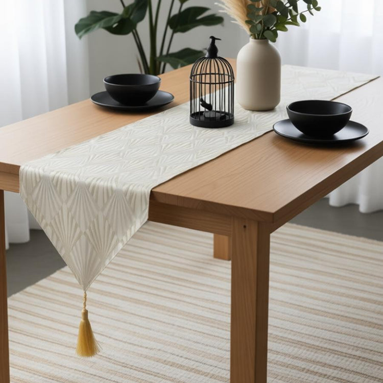 Pale gold geometric table runner with a pointed tasselled end.