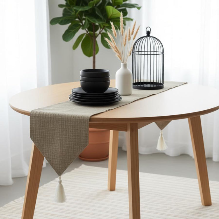 Sand-coloured table runner draped over a small round table.