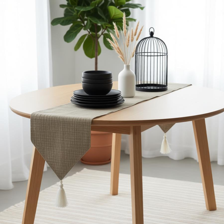 Sand-coloured table runner draped over a small round table.