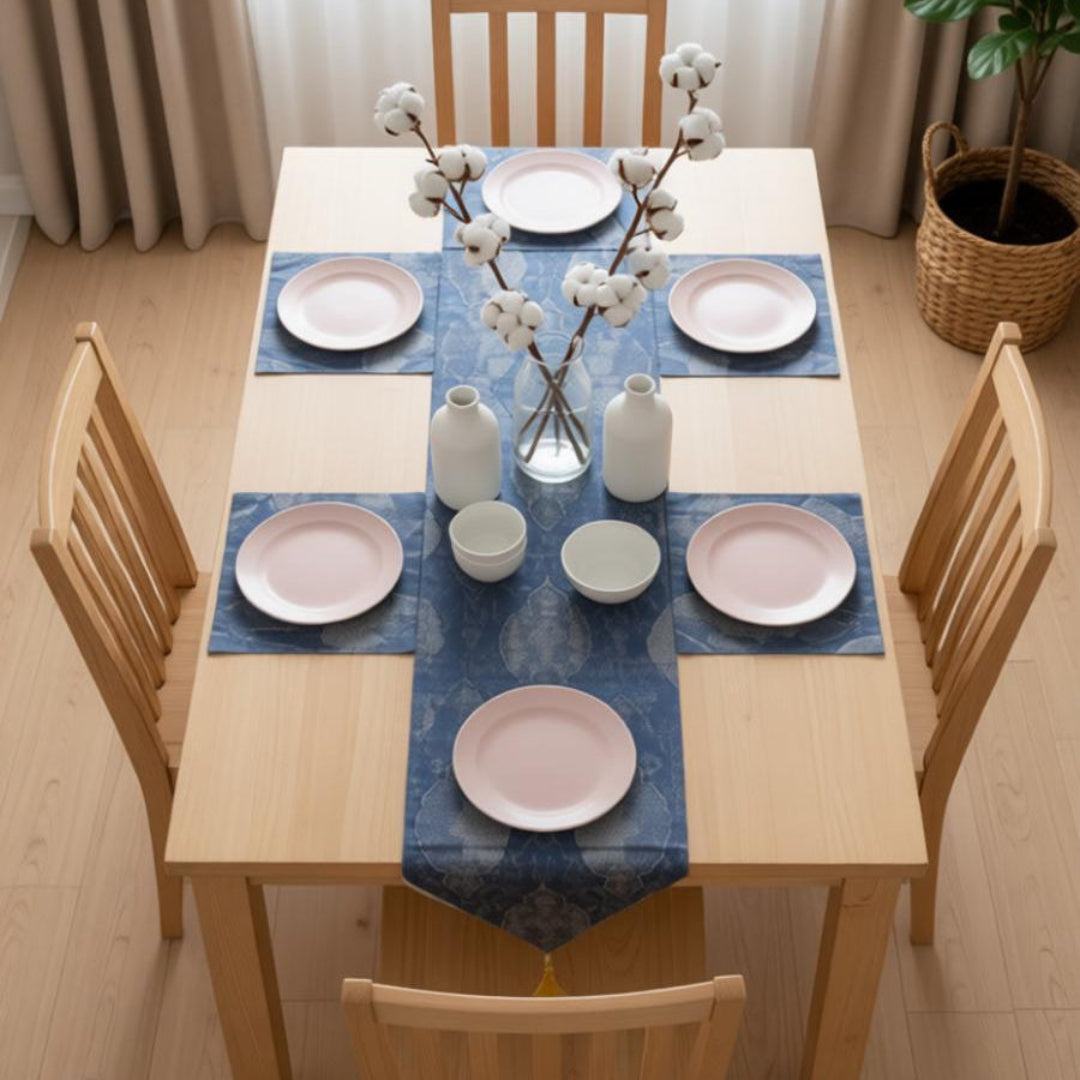 Dark blue table runner with gold-toned ornamental motifs and matching placemats.