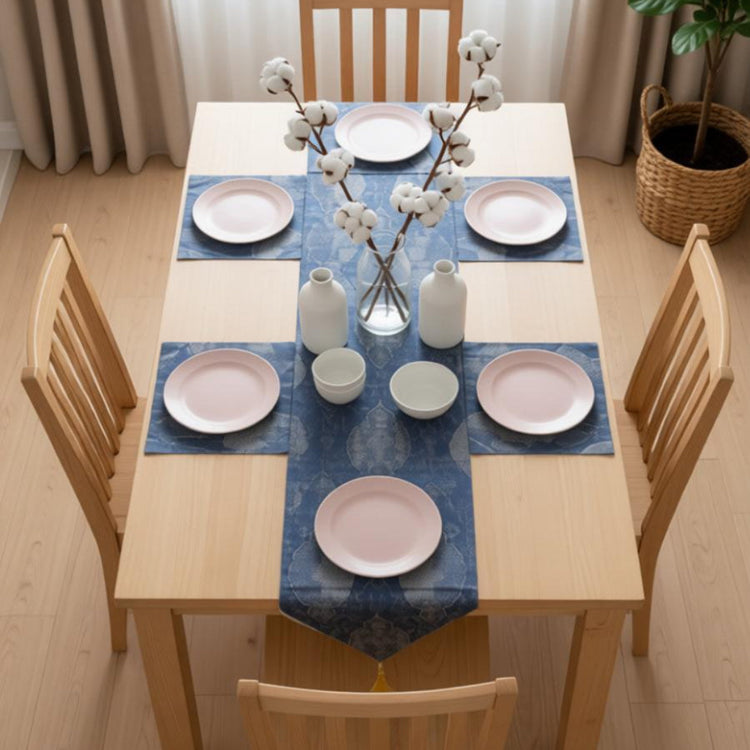 Dark blue table runner with gold-toned ornamental motifs and matching placemats.