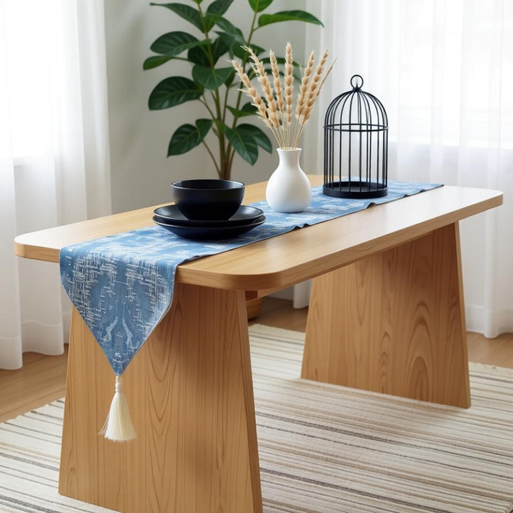 Light blue damask table runner draped over a wooden table.