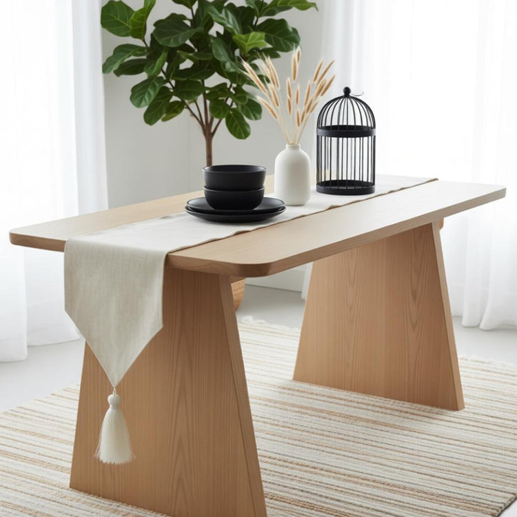 Pale gold neutral table runner with a pointed tasselled end.