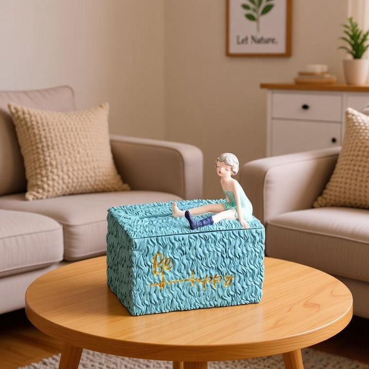 Turquoise textured tissue box decorated with a reclining girl figurine.