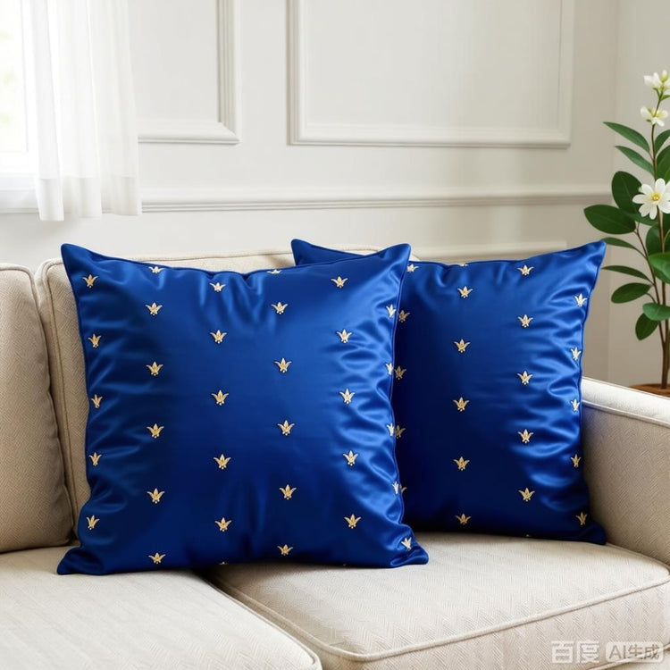 Two blue cushion covers with small gold coloured motifs on a cream armchair.