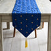 Royal blue velvet table runner with small gold-coloured motifs and a tasselled point.
