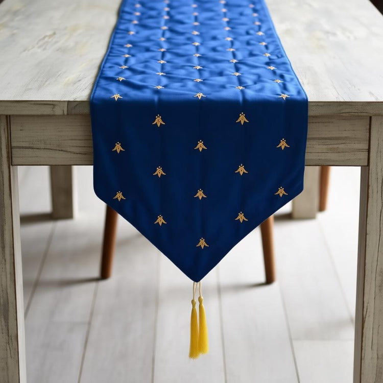 Royal blue velvet table runner with small gold-coloured motifs and a tasselled point.