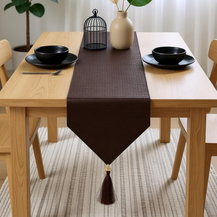 Dark brown textured table runner with a pointed tasselled end.