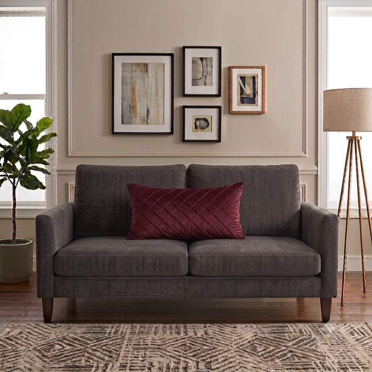 Rectangular burgundy filled cushion with diamond stitching on a dark grey sofa.