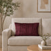 Rectangular burgundy filled cushion with vertical stitched texture on a cream sofa.
