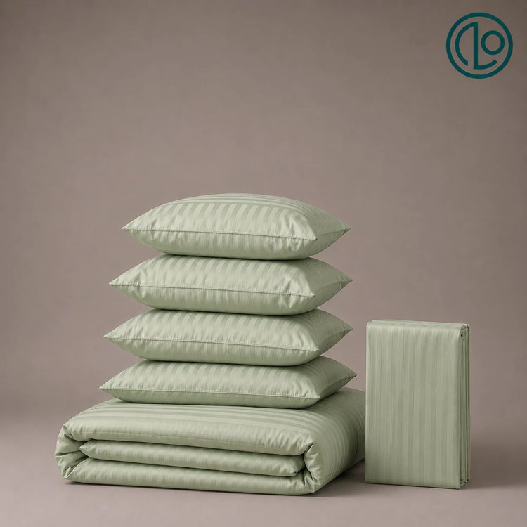 Stacked sage green striped pillowcases and folded bed linen.