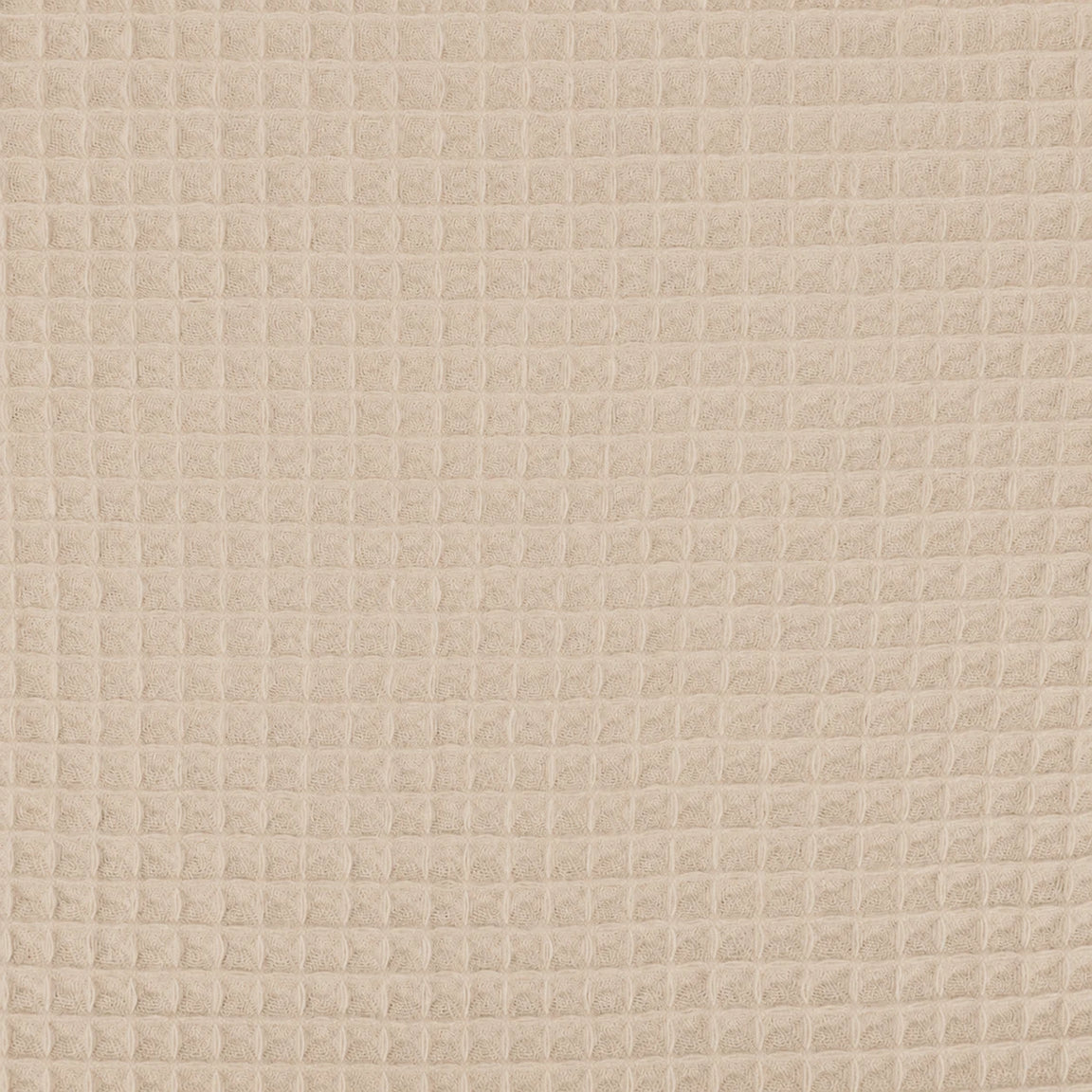 Close-up of the beige grid texture of a cotton thermal blanket.