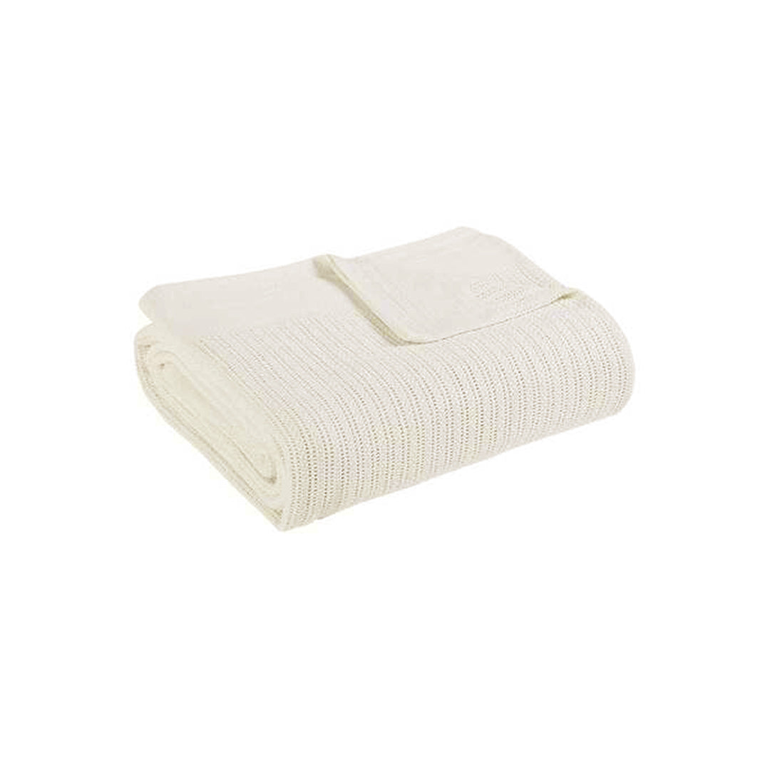 Folded cream ribbed cotton thermal blanket.