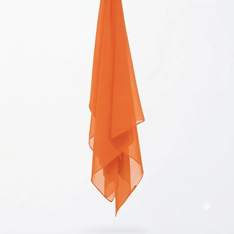 Orange chiffon stole hanging vertically to show its light fabric.