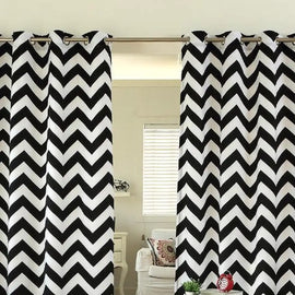 Black and white chevron eyelet curtains hanging at a window.