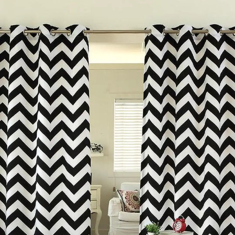 Black and white chevron eyelet curtains hanging at a window.