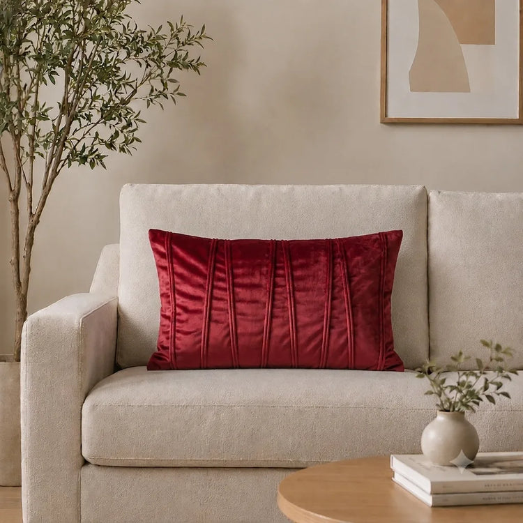 Rectangular red filled cushion with vertical stitched texture on a cream sofa.
