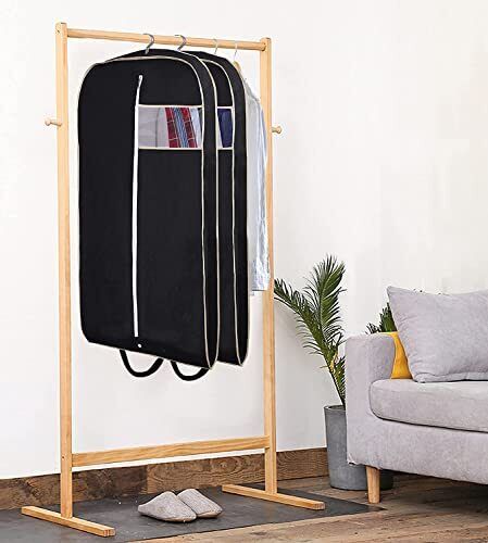 Black garment bag hanging on a wooden clothes rail.