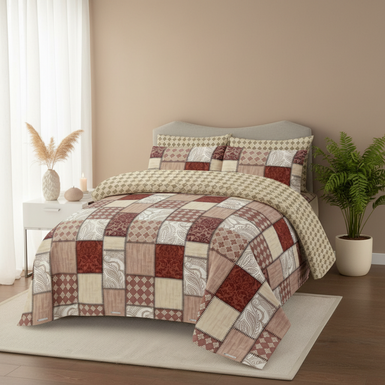 Cream and burgundy patchwork-print bedsheet and matching pillowcases on a bed.