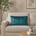 Rectangular teal filled cushion with vertical stitched texture on a cream sofa.