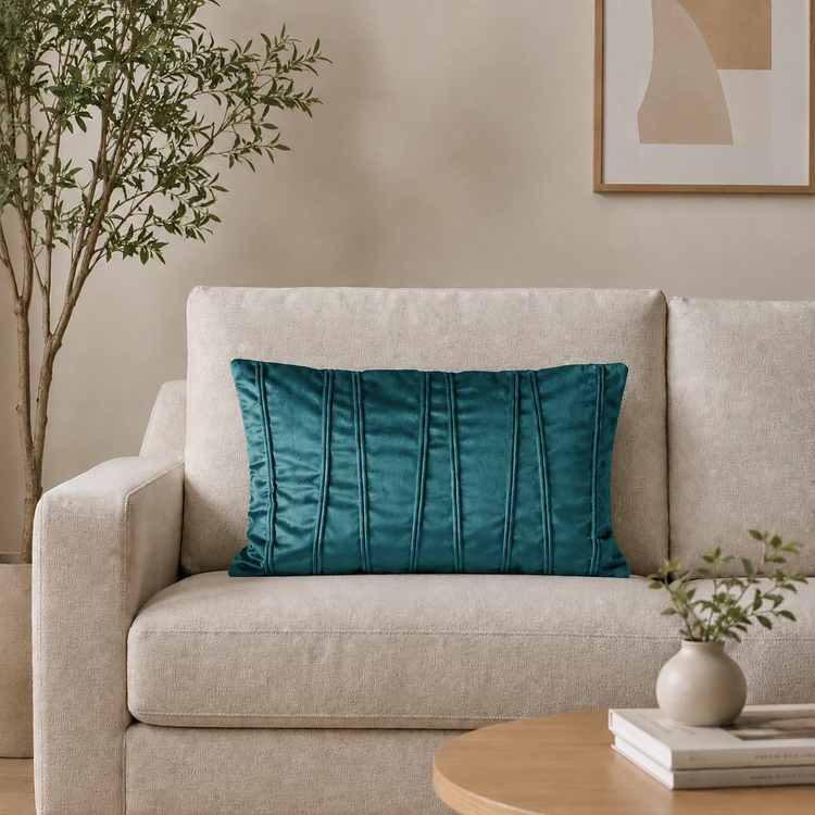 Rectangular teal filled cushion with vertical stitched texture on a cream sofa.