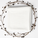 Folded white ribbed blanket framed by decorative dried branches.
