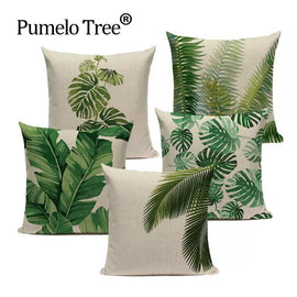 Five cream cushion covers with assorted green tropical leaf prints.