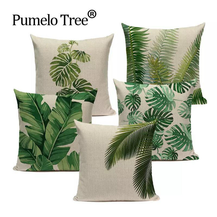 Five cream cushion covers with assorted green tropical leaf prints.