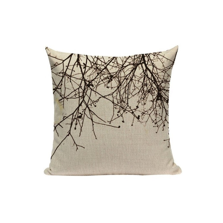 Cream cushion cover with black branches hanging from the top edge.