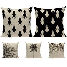 Five cream and black cushion covers with tree, branch and palm designs.